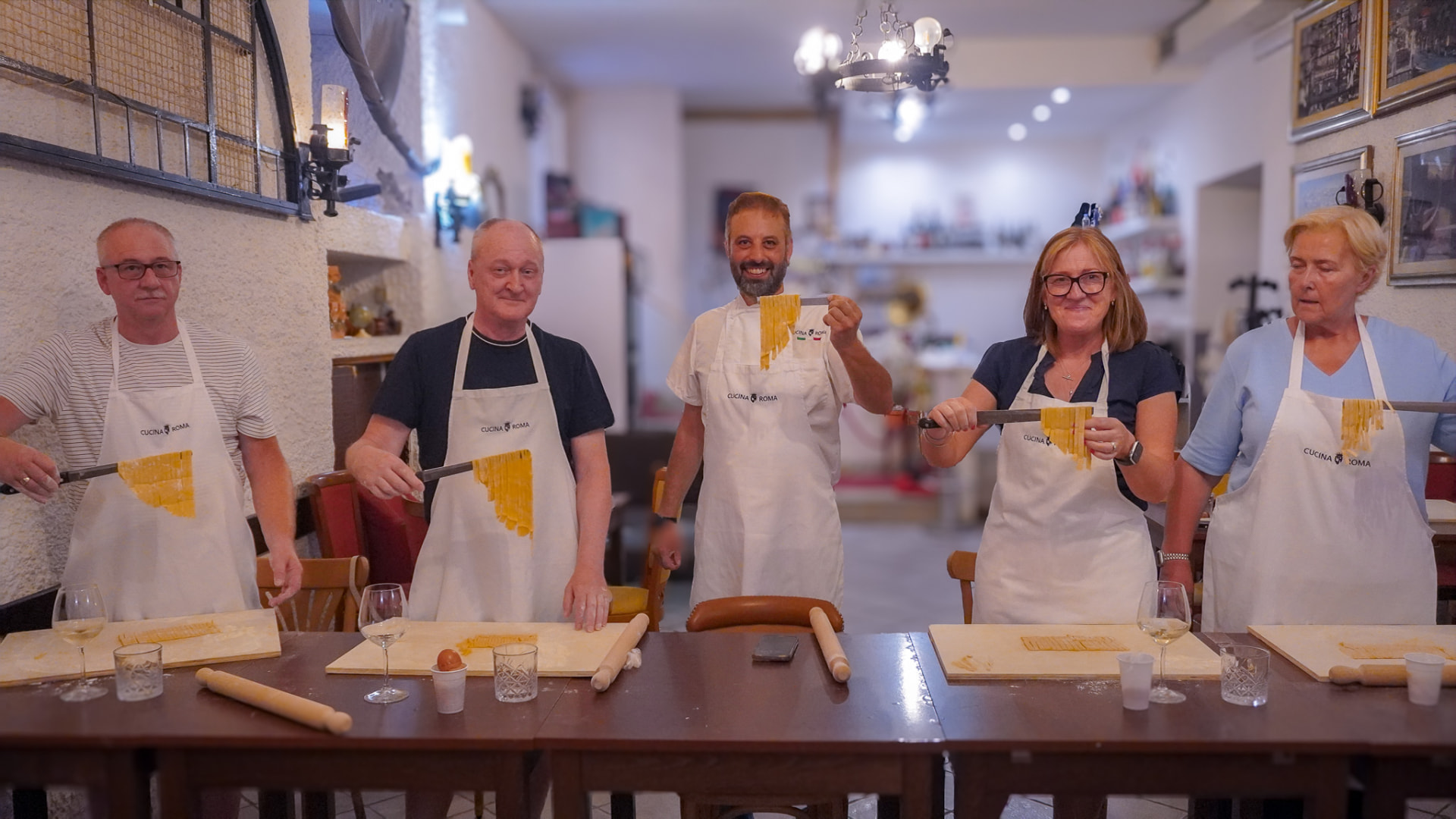 Gruppo privato che prepara pasta fresca a mano durante la private class di Cucina Roma